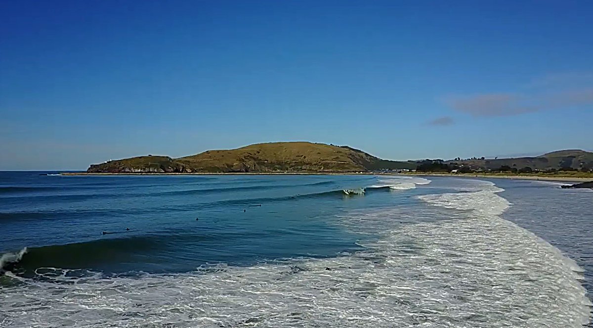 Clean lines wrap into the bay below the headland on a bright, offshore Otago day, Aramoana surf spot, Dunedin / Otago, New Ze