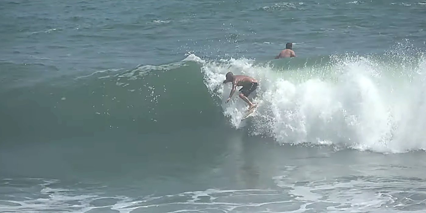 Two surfers trade a clean green peak on a lighter day at the river-mouth bar, Blaketown - Cobden surf spot, West Coast South 