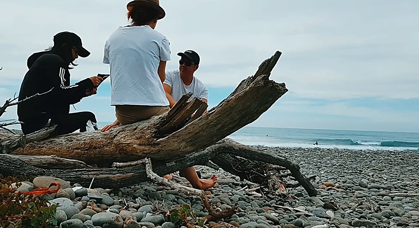 Mates hanging out on the driftwood while the crew trades peaks out the back, the easy rhythm of a Gore Bay session, Gore Bay 