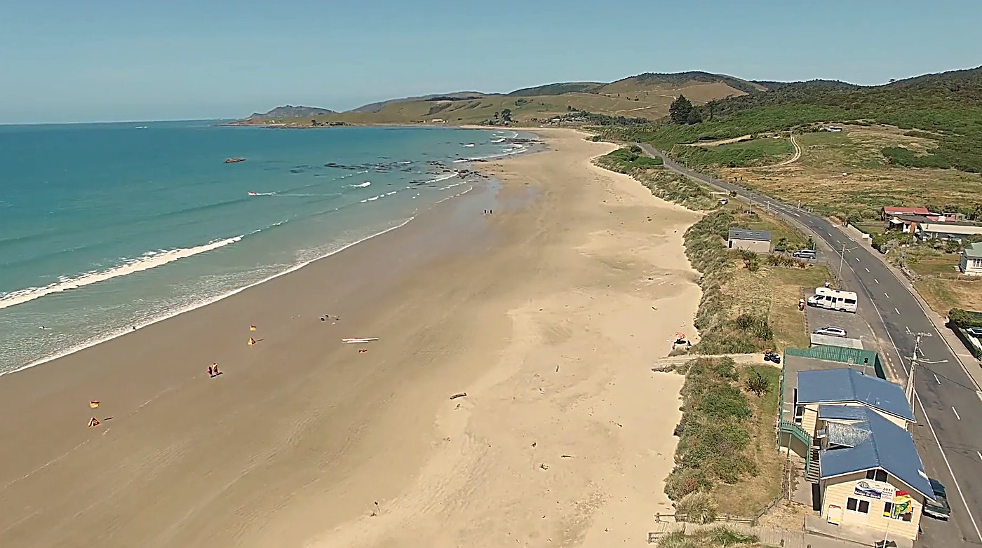 The patrolled beach below the dunes, the surf club and flags out on a warm Catlins day, Kaka Pt surf spot, Catlins / South Ot