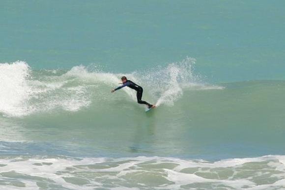 Laying into a turn off the top as the wave wraps around the boulder bank, Magnet Bay surf spot, Canterbury, New Zealand.