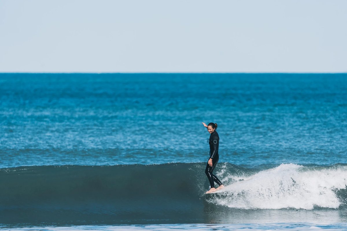 A mellow day for a longboard, walking the nose under the Cavallis, Matauri Bay surf spot, Northland East, New Zealand.