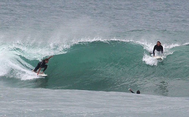 Classic Main Beach session: two surfers on a wave with a third paddling out, Mt Maunganui - Main Beach surf spot, Bay of Plen