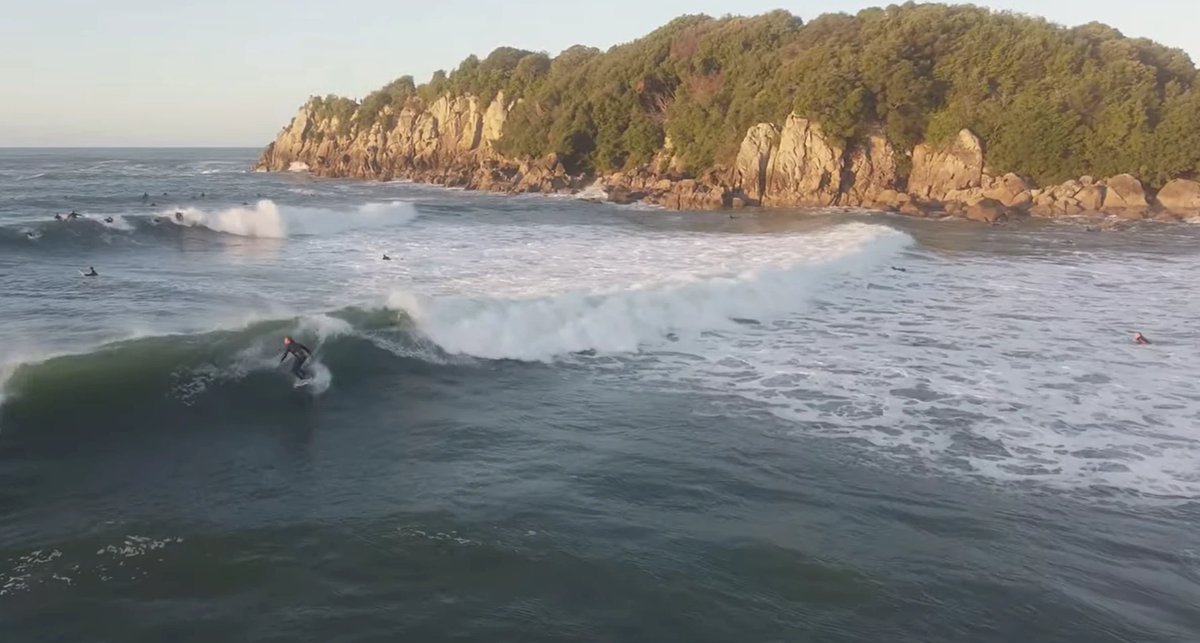 Golden-hour wave wrapping around the Blowhole point with surfers up the line, Mt Maunganui - Main Beach surf spot, Bay of Ple