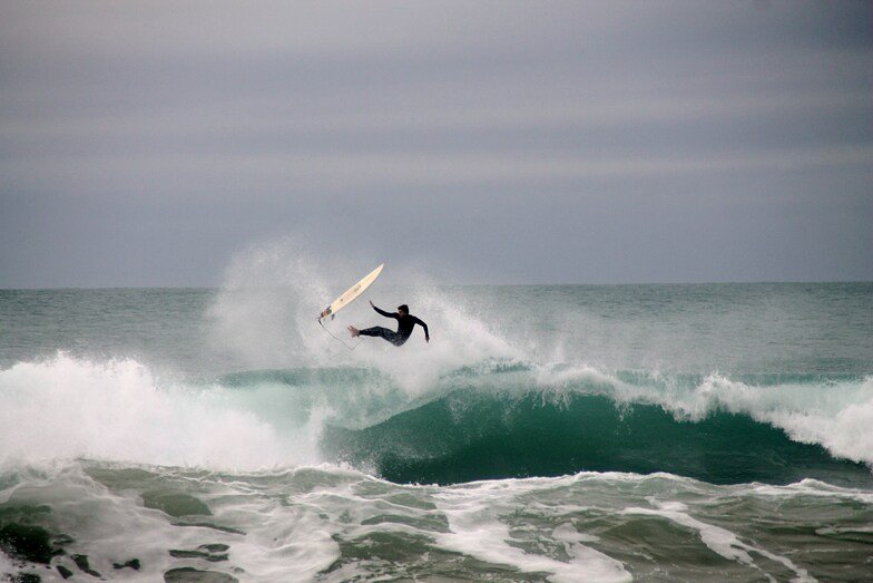 Boosting off the lip on a grey, glassy afternoon when the reefs have some punch, Ōkato surf spot, Taranaki / SH45, New Zealan