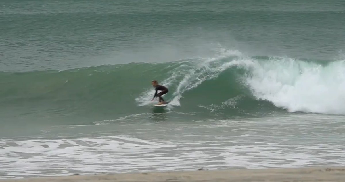 Clean head-high wave on a working day with the long beach behind, Otama surf spot, Coromandel, New Zealand.