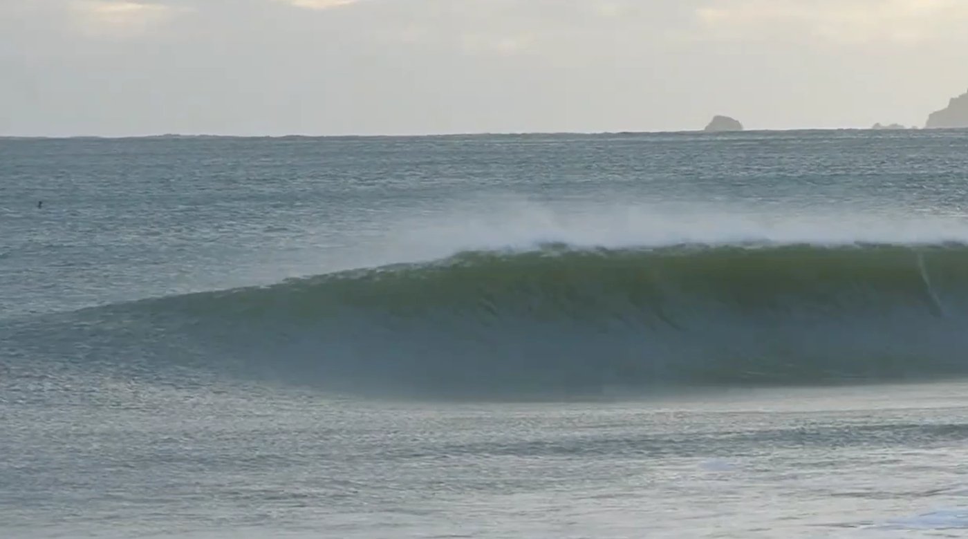 Clean empty wedge at dawn with mist coming off the back, Otama surf spot, Coromandel, New Zealand.