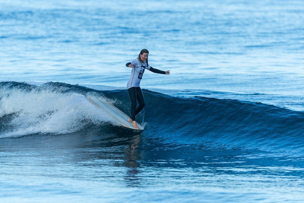Solo longboarder noseriding a glassy Pāpāmoa wave, Pāpāmoa surf spot, Bay of Plenty, New Zealand.