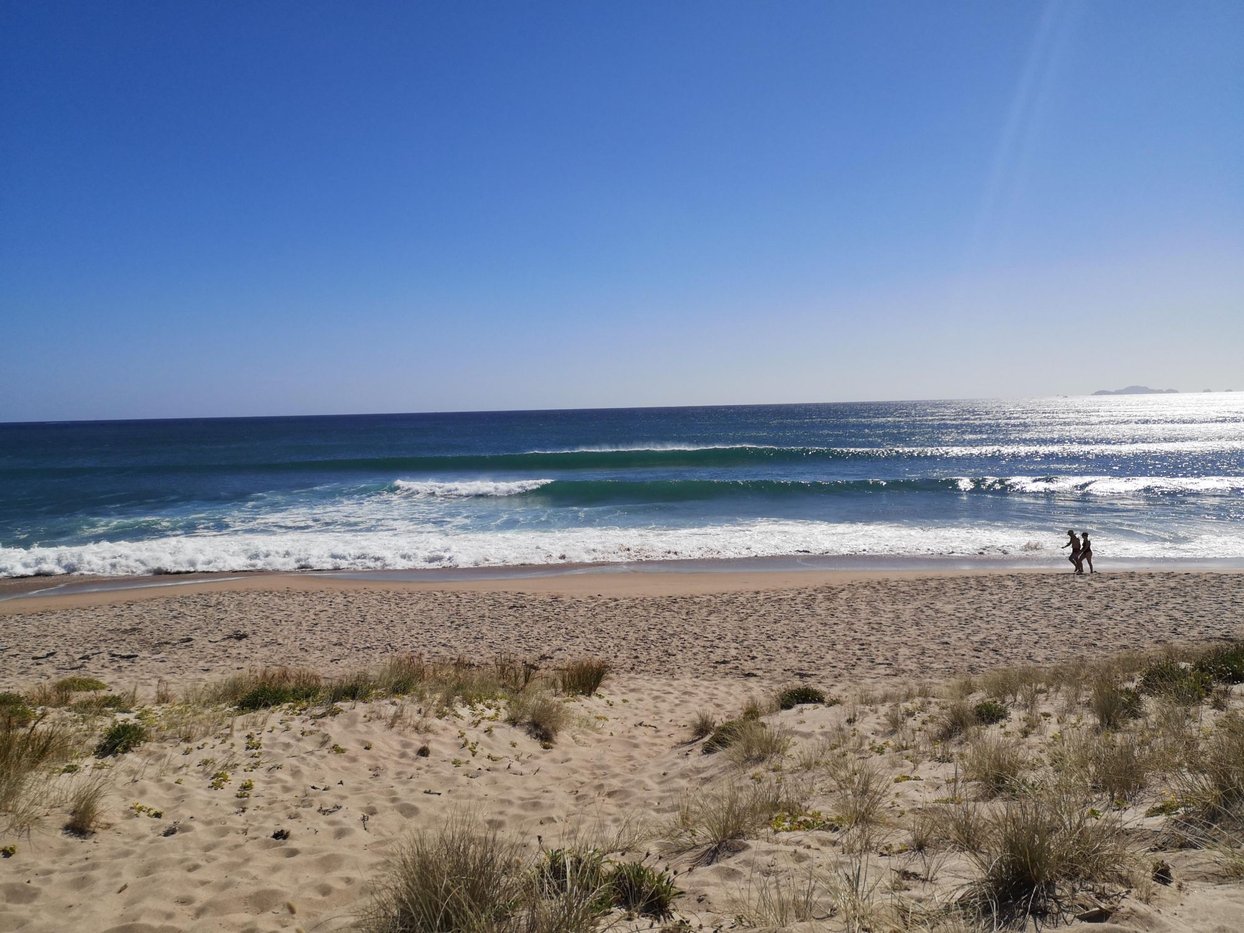 Clean wave on Ocean Beach with the Aldermen Islands faint on the horizon, Tairua surf spot, Coromandel, New Zealand.