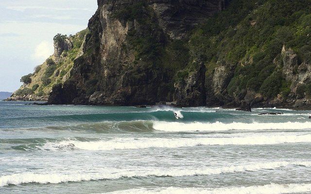 Riding under the southern headland, Taupo Bay surf spot, Northland East, New Zealand.