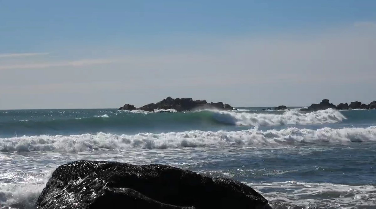 Sets feather over the offshore rocks at the southern end, where the bay tucks in below Cape Foulwind, Tauranga Bay surf spot,