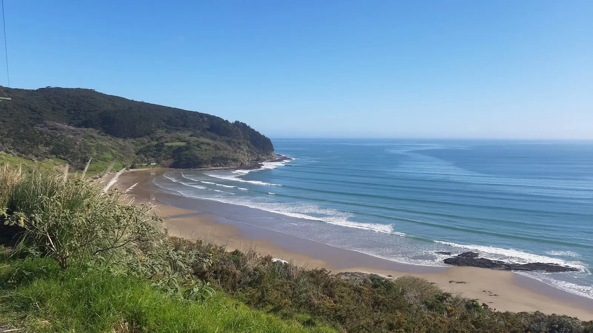 Looking down the bay from the cliff above Wreck Bay Road, Tauroa / Shipwreck Bay surf spot, Northland West, New Zealand.