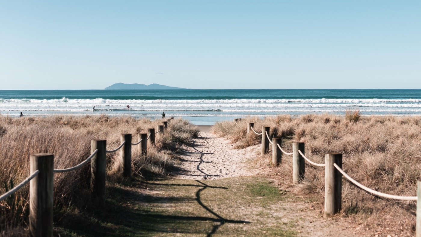 The walk down to the beach with Mayor Island (Tūhua) on the horizon. The view that gets surfers off the road and into the wat