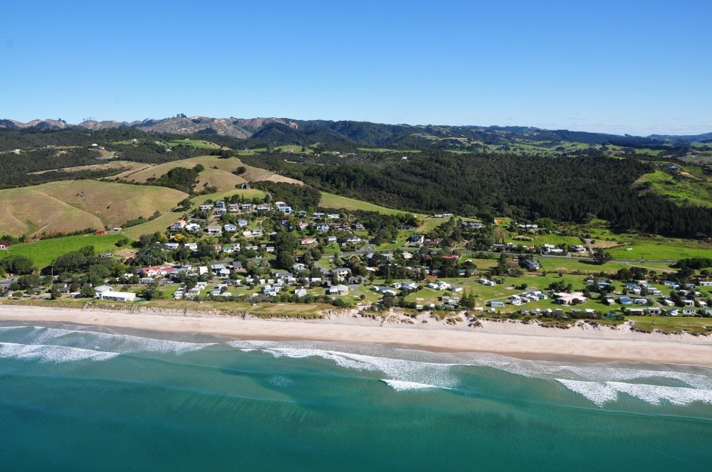 Looking back over the village from the air, Waipū Cove surf spot, Northland East, New Zealand.