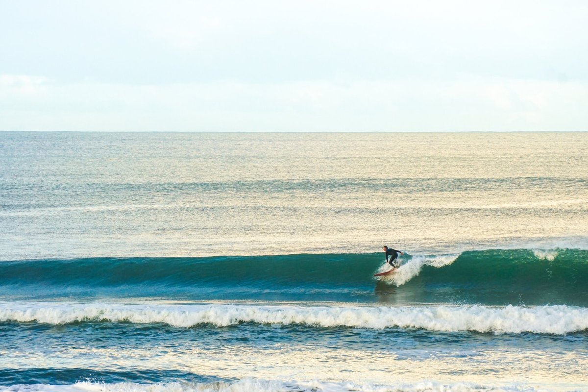 Golden hour cruise on a longboard. Most beach days have peaks for every kind of session, Whangamatā surf spot, Coromandel, Ne